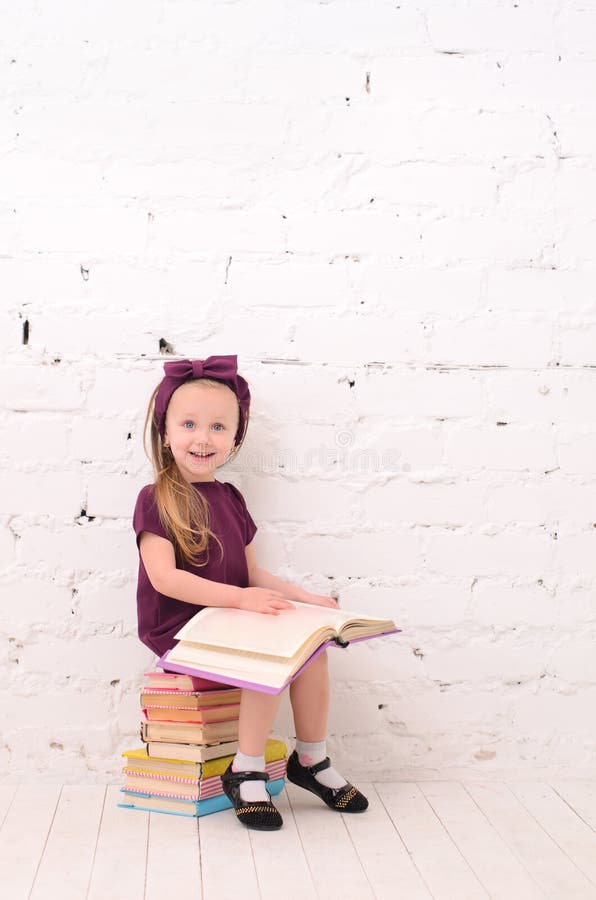 Girl reading a book, sitting on a pile of books stock image Girl reading a book, sitting on a pile of books stock image