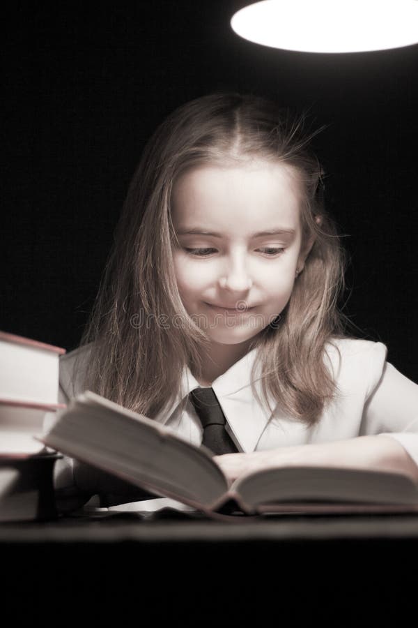 Girl reading book under lamp