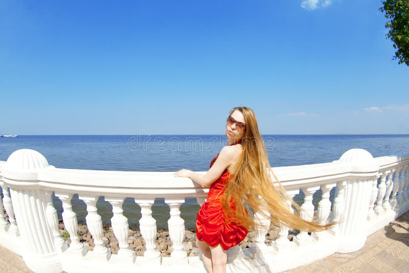 Girl in the red dress on the beach