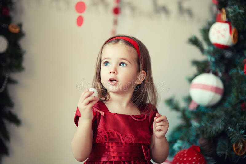 Girl in a red dress the Christmas tree