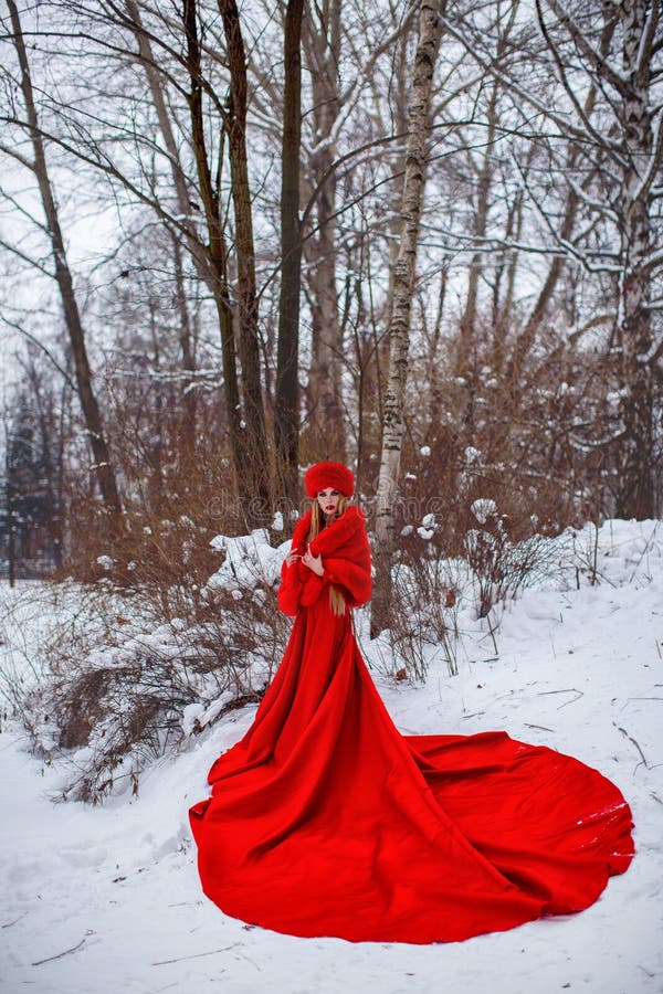 Girl in red dress in winter forest