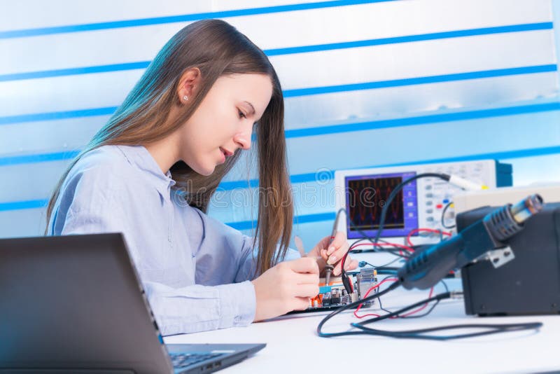 Girl repairing electronic device on circuit board
