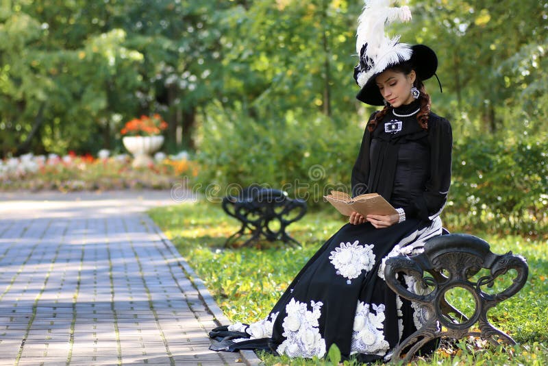 Girl in retro dress past century read letter on the bench stock images Girl in retro dress past century read letter on the bench stock images
