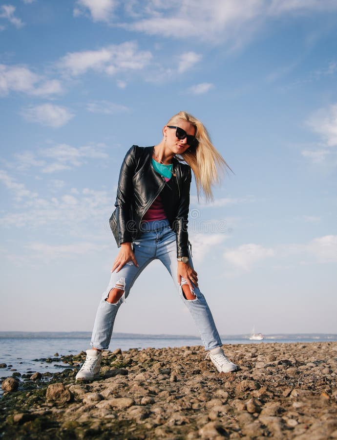 Girl in Ripped Jeans Having Fun on the Shore of the Blue Sea Stock ...