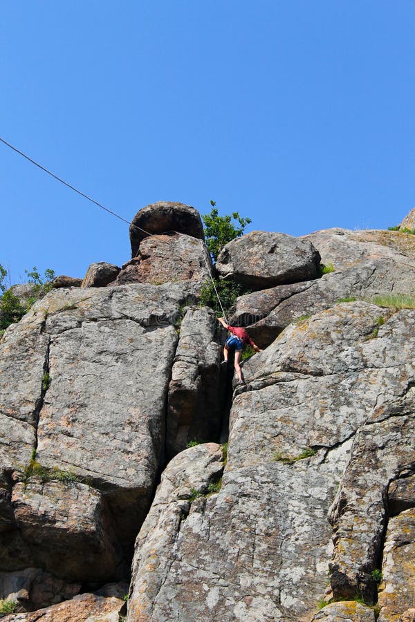 Girl rock climber climbs on a rock stock photo Girl rock climber climbs on a rock stock photo