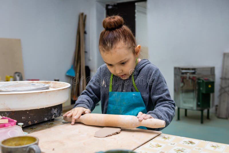 Girl Rolls Clay with a Rolling Pin. Stock Photo Image of master