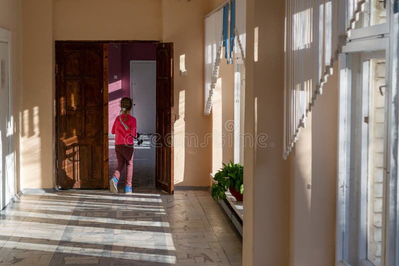 a girl runs down the hallway of the school. stock photo