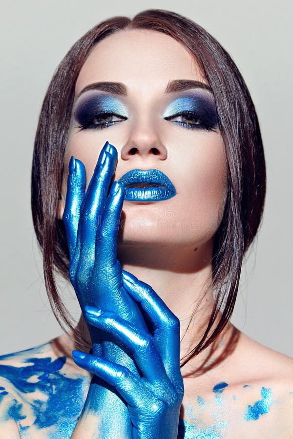 Girl with Blue Makeup, with Blue Nails on a Pink Background. Stock