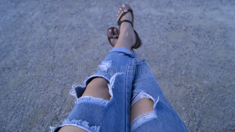 Girl`s legs dressed in ripped blue jeans stock photos Girl`s legs dressed in ripped blue jeans stock photos