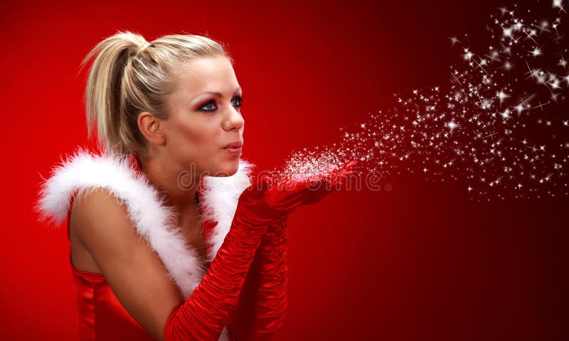 Girl in santa cloth blowing snow