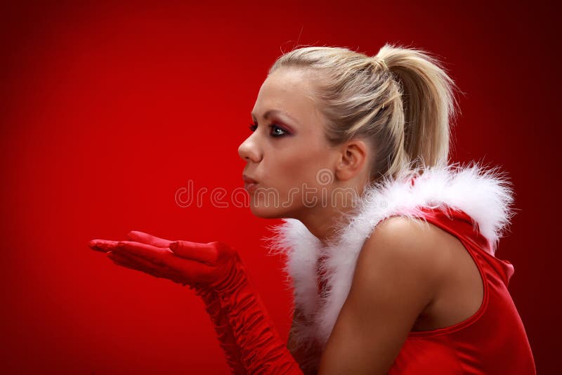 Girl in santa cloth blowing snow