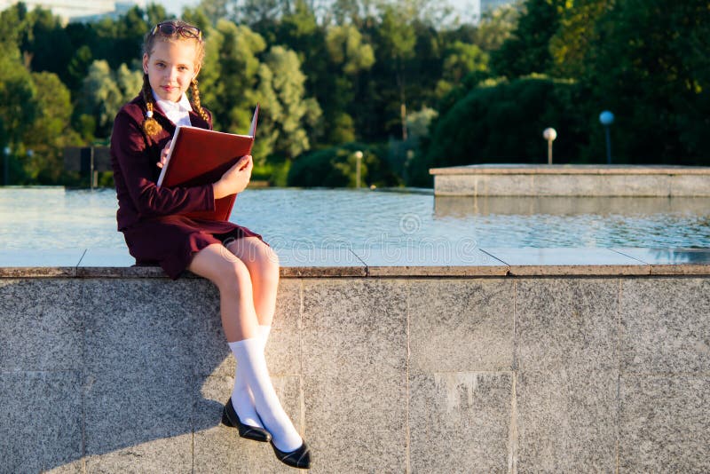 Girl after school classes sits in a park in the fresh air royalty free stock photography Girl after school classes sits in a park in the fresh air royalty free stock photography