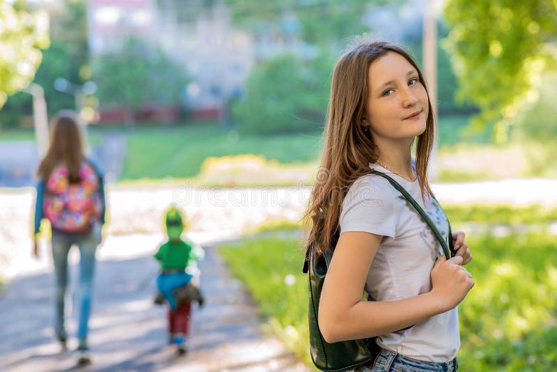 Girl Schoolgirl In The Summer In Park In Nature Behind The Backpack Free Space For Text In 