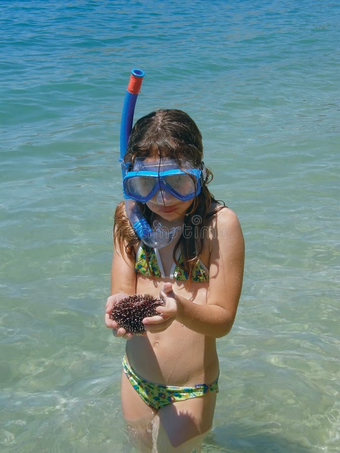 Girl in sea with diving mask keeping sea urchin in hands at Adriatic sea (Croatia-Dalmatia). Girl in sea with diving mask keeping sea urchin in hands at Adriatic sea (Croatia-Dalmatia)