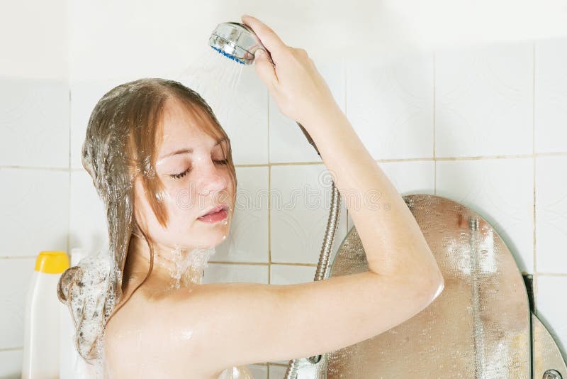 Girl shampooes with shower stock photos
