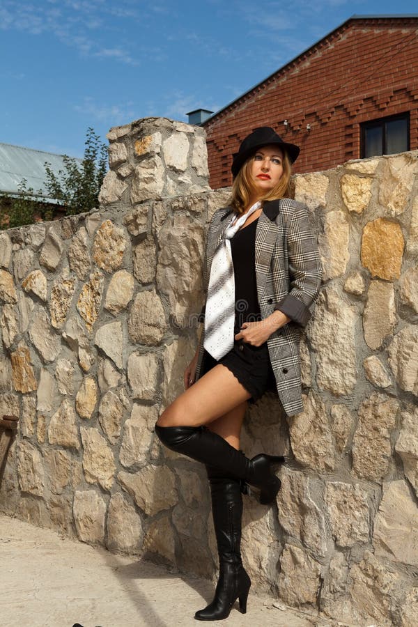 Girl in shorts and a man's suit posing with hat stock photo Girl in shorts and a man's suit posing with hat stock photo