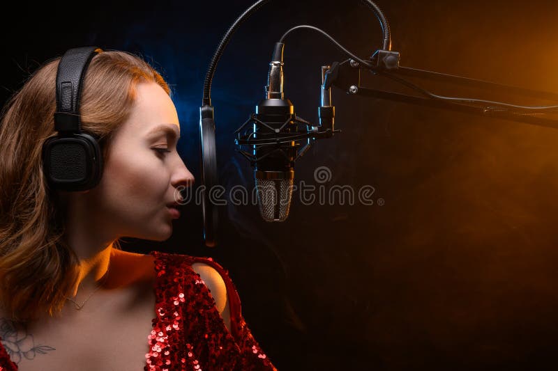Girl singing into a microphone. Love for music. Screensaver for learning music or vocals royalty free stock photo Girl singing into a microphone. Love for music. Screensaver for learning music or vocals royalty free stock photo
