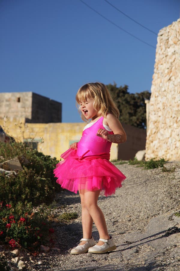 Girl singing in pink ballet dress.