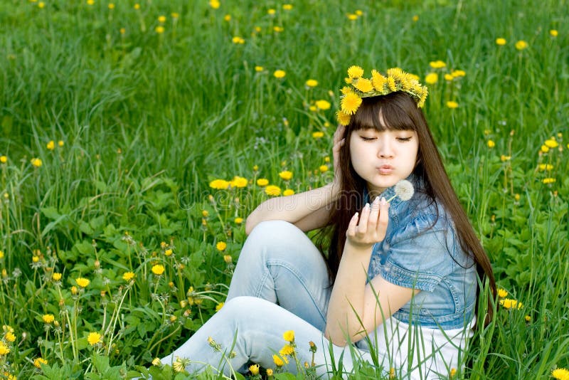 Girl sitting among dandelions