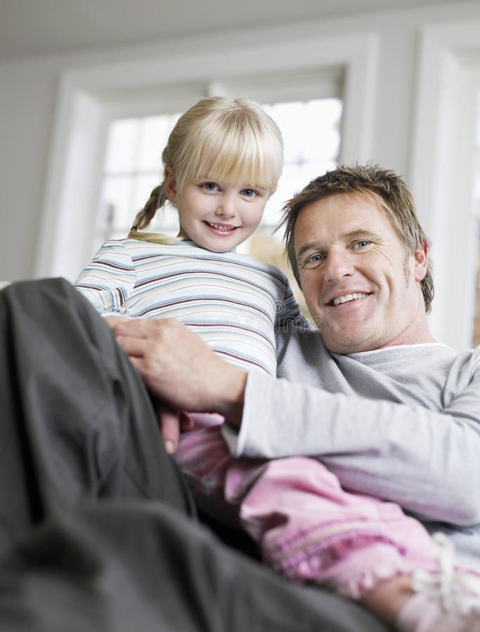 Girl Sitting on Father S Lap in House Stock Im image