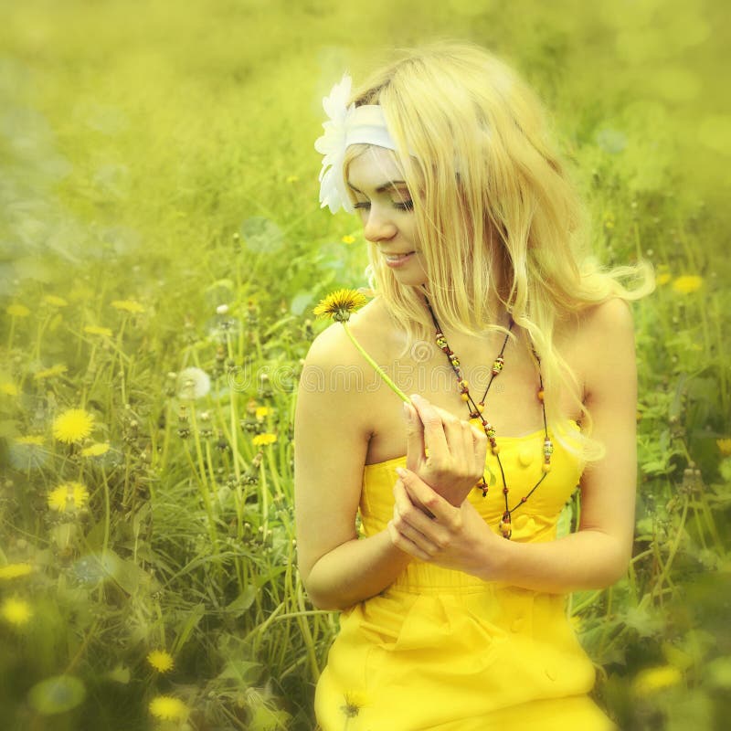 Girl sitting in field with camomiles.