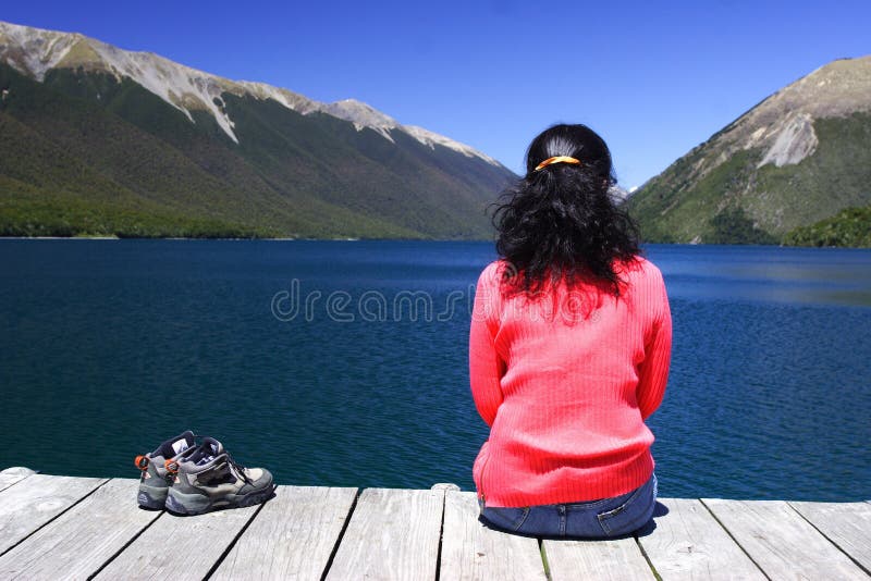 A girl sitting by the lake