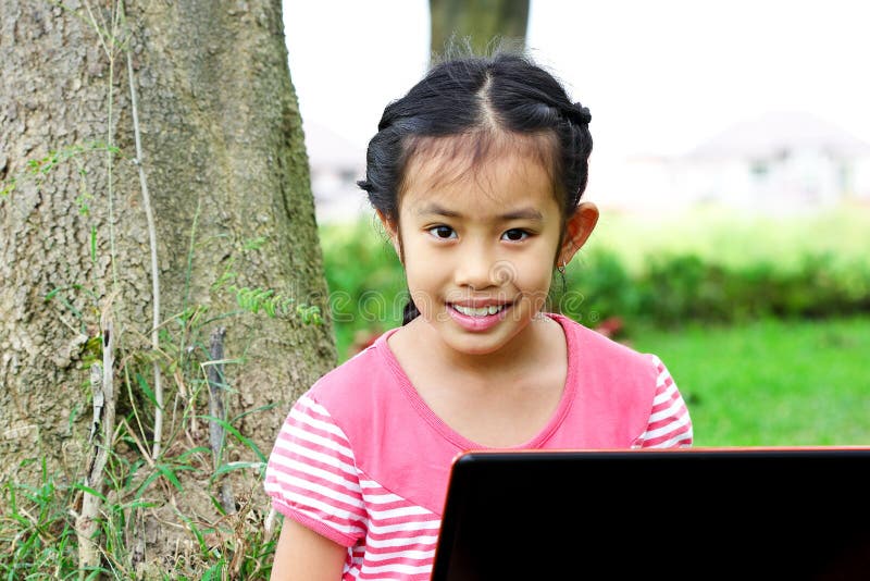 Girl sitting in park with a laptop