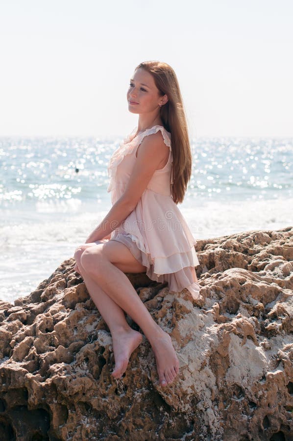 Girl sitting on a rock stock photos Girl sitting on a rock stock photos