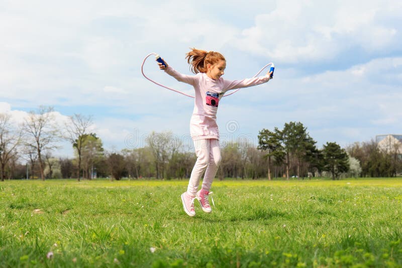 Girl with skipping rope in the field
