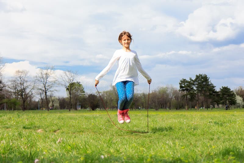 Girl with skipping rope in the field