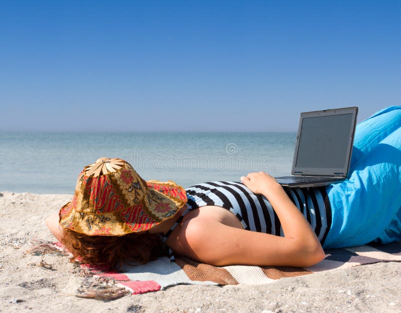 Girl sleep with laptop computer at sea beach stock photos