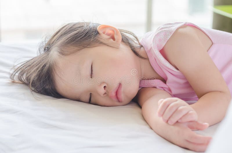 Girl sleeping on bed at day time