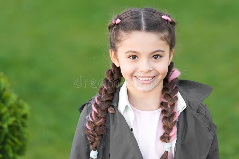 Girl small kid with fashionable braids hairstyle. Fashion trend. Salon and hair care. Girl cute smile face outdoors royalty free stock images
