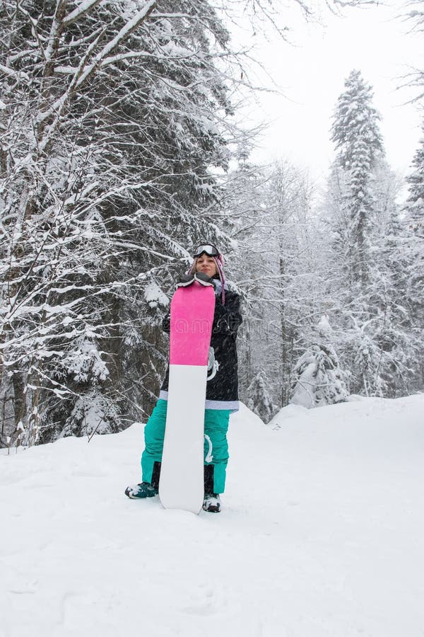 Girl with a Snowboard in the Forest in the Mountains and the Snowfall ...