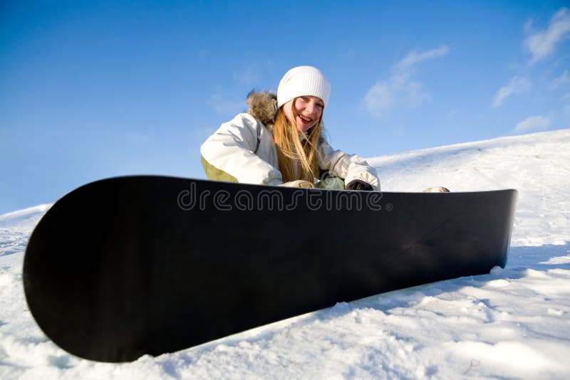 Girl with snowboard on snow