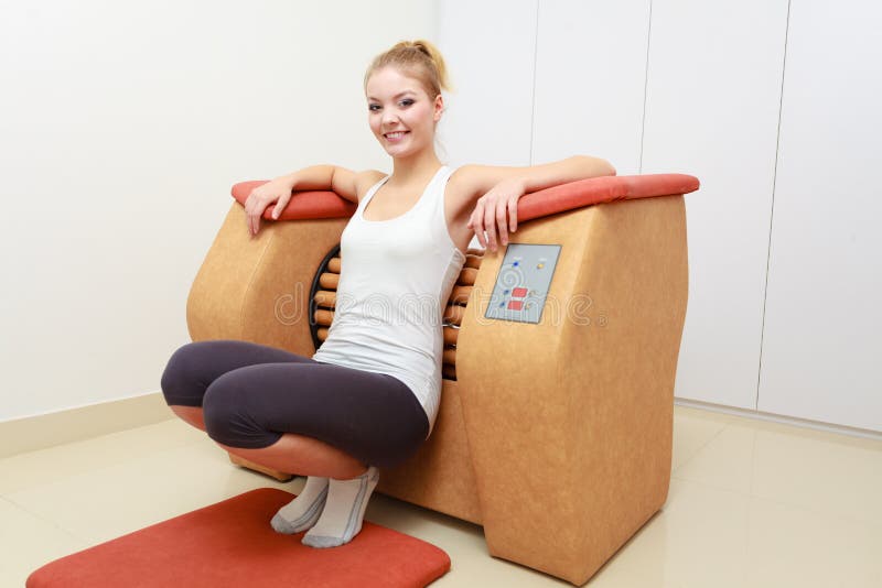 Girl in sportwear using relax massage equipment healthy spa salon