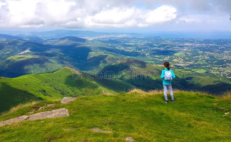 Girl standing with her back to see the landscape from Mount Larrun. Demarcation between the border of Spain and France in the stock photography Girl standing with her back to see the landscape from Mount Larrun. Demarcation between the border of Spain and France in the stock photography