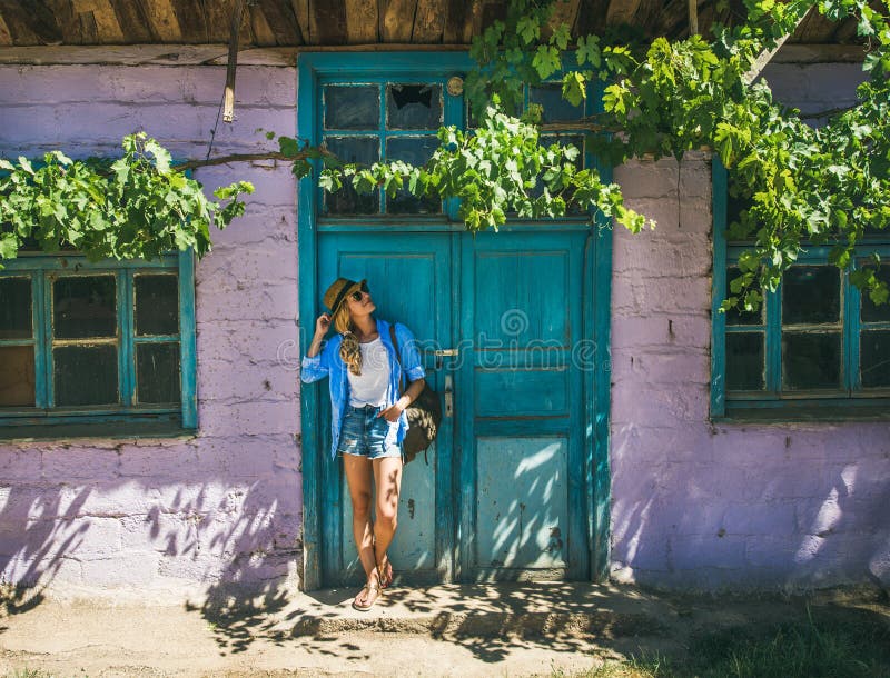 Girl standing near purple wall in Turkish village in summer