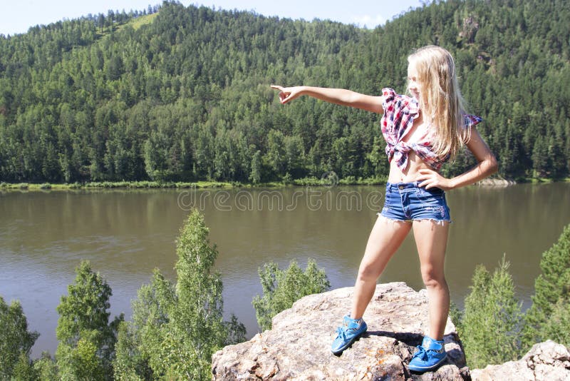 Girl standing on a rock and enjoying river view