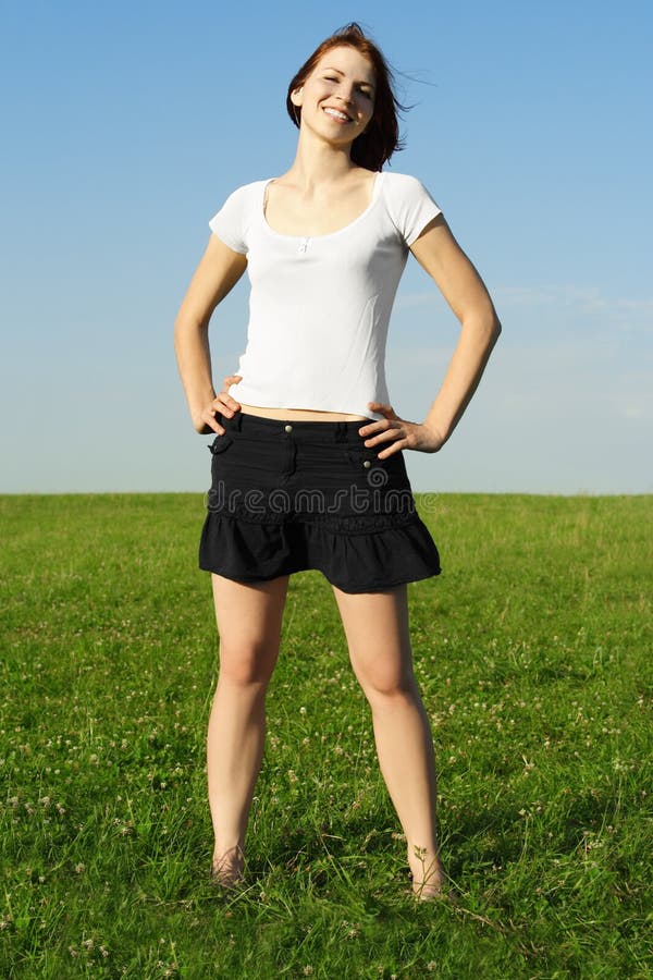 Girl standing on summer meadow and smiling