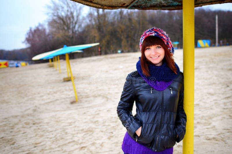 Girl standing under an umbrella on the beach in autumn royalty free stock photography Girl standing under an umbrella on the beach in autumn royalty free stock photography