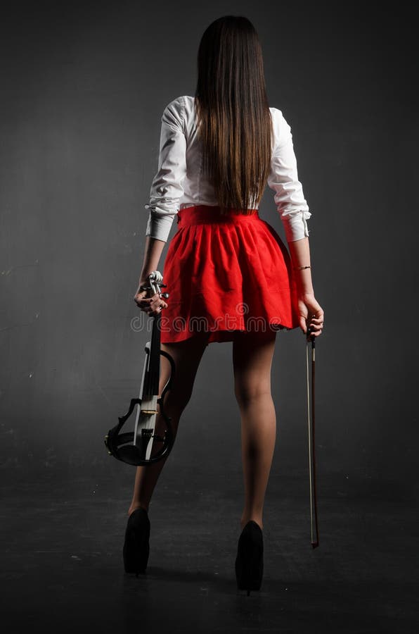 Girl stands back to the photographer with violin