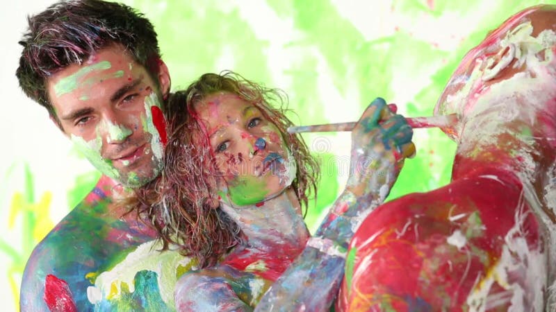 Girl stands between two young men and draws with stock video footage