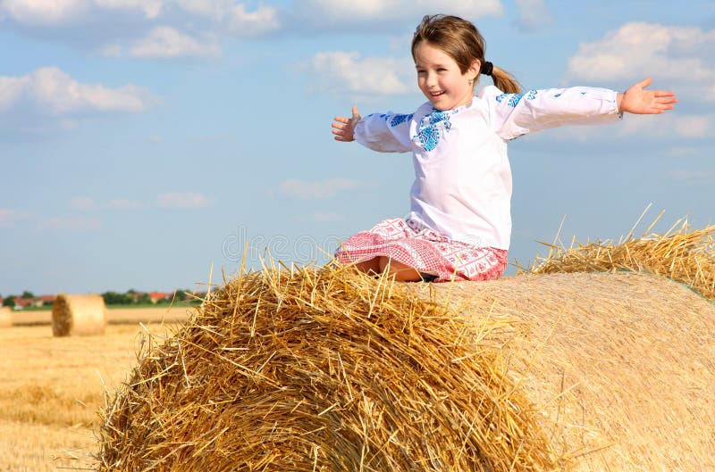 Girl on the straw after harvest field