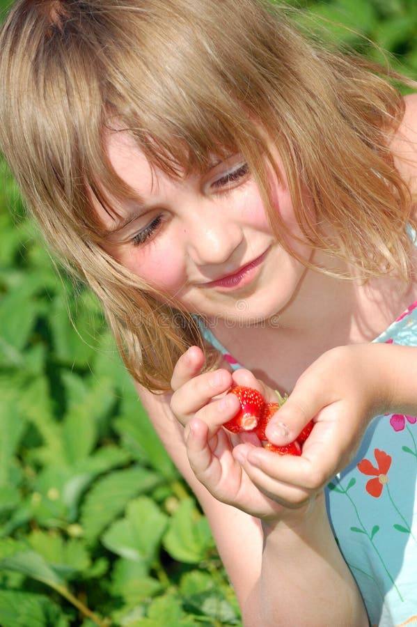 Girl with strawberries in the field