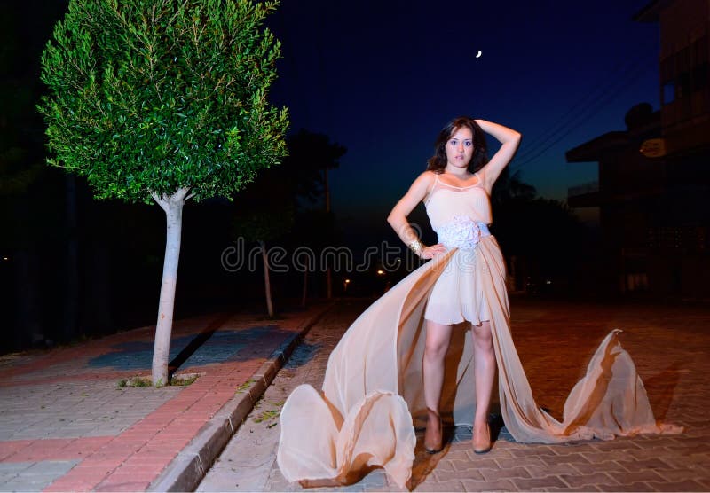 Girl on the street at night in flying dress