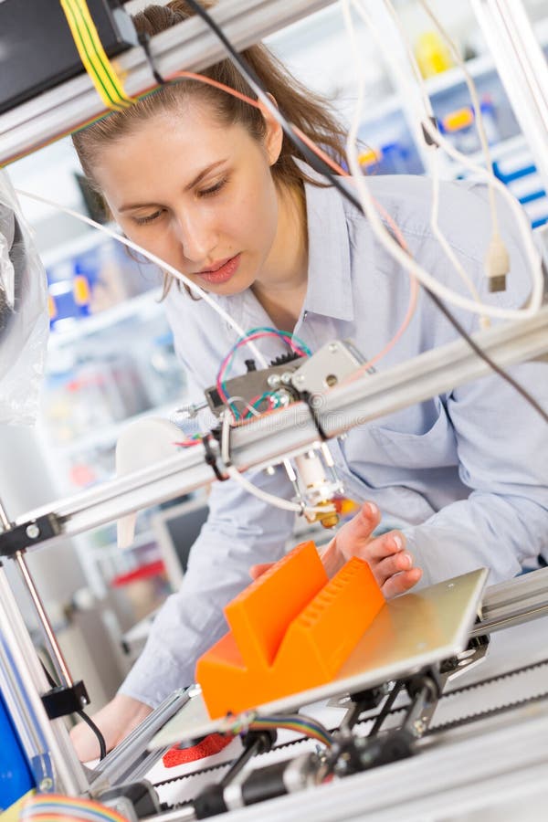 Girl student makes the item on 3D printer royalty free stock photo