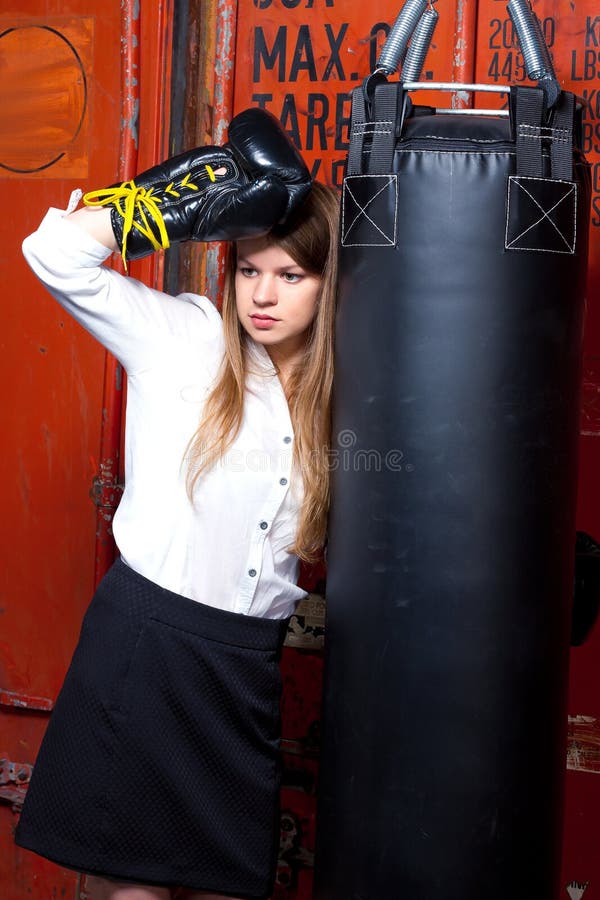 Girl in a suit near punch bag