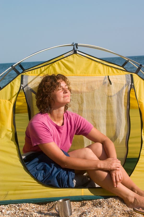 Girl sunburning in the morning near of tent