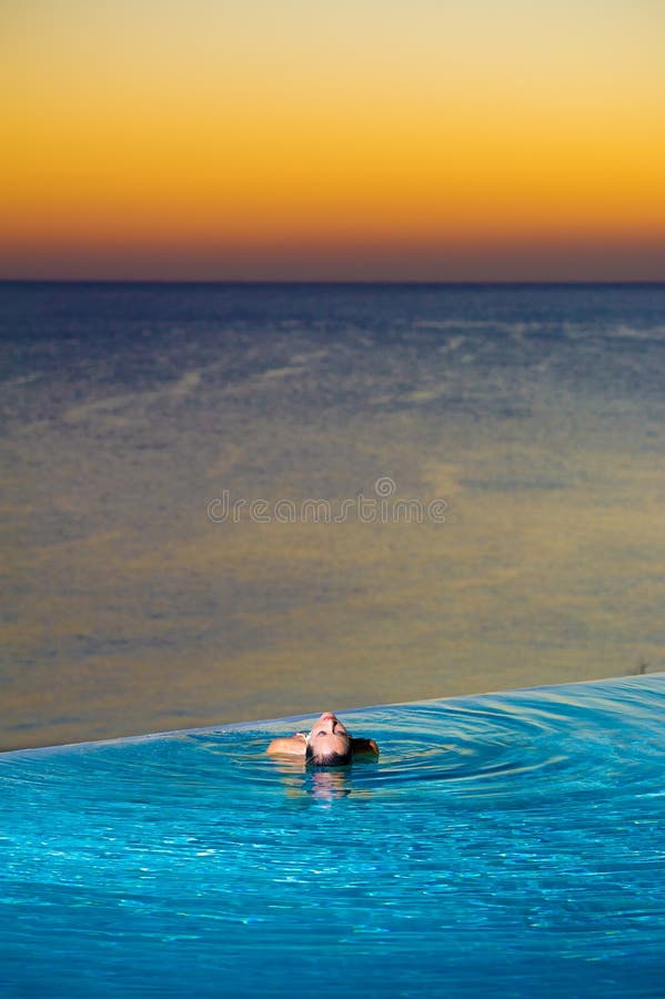 Girl in Sunset infinity pool